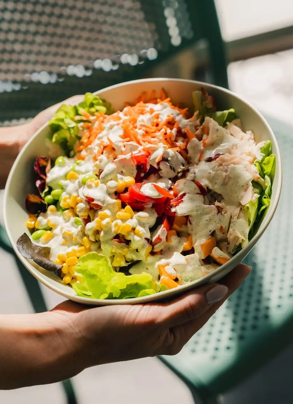 Un bowl de crudités garni, tenu à la main