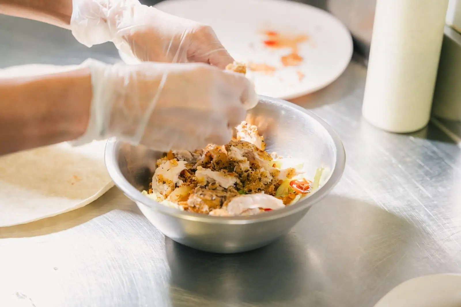 Un bowl garni à la main en cuisine, avant d’être servi