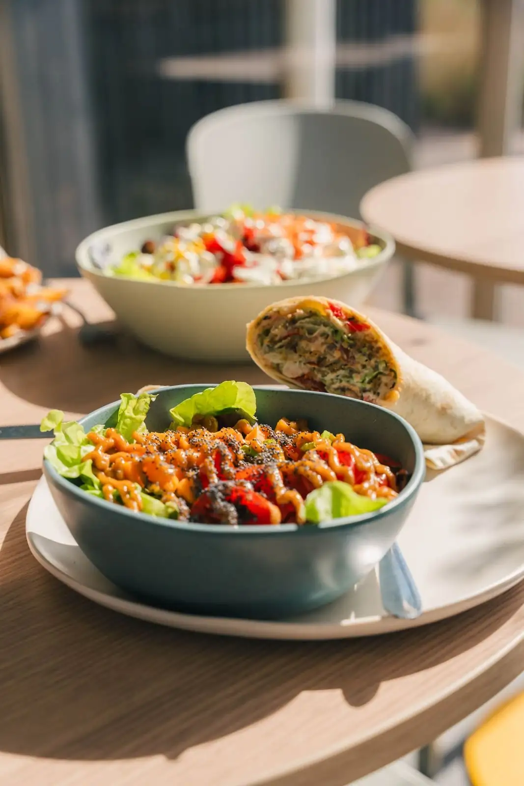 Deux bowls garnis et un wrap servis en salle
