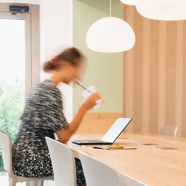 Une cliente installée à la grande tablée, ordinateur ouvert
